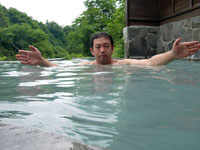 周囲を緑に囲まれた猿倉温泉の露天風呂。お湯は白濁というよりもエメラルドグリーンに近い色となっている